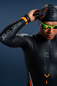 Close-up of male athlete wearing Rocket Science Sports Aquasense wetsuit, adjusting swim cap, showing Aqua Sense sleeve branding and Ultra Flex chest panel