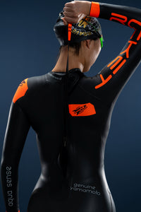 Back view of woman pulling reverse zipper on Rocket Science Sports Viper wetsuit with hydro-seal neckline