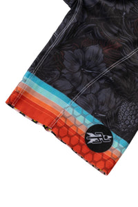 Close-up of a floral-patterned fabric with a colorful border and a logo on a white background